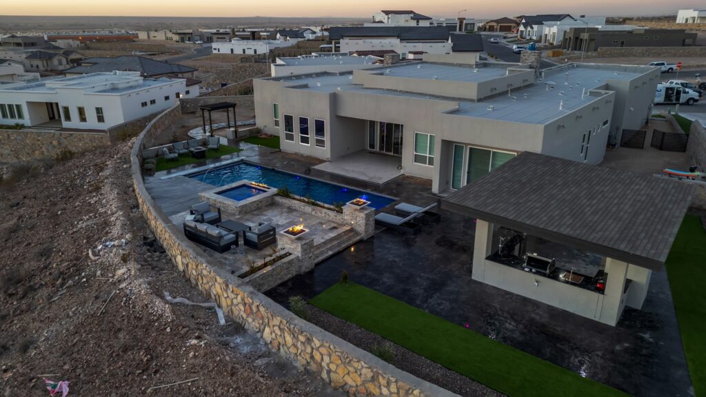 Full backyard overview featuring custom pool, fire features, and patio in El Paso, TX