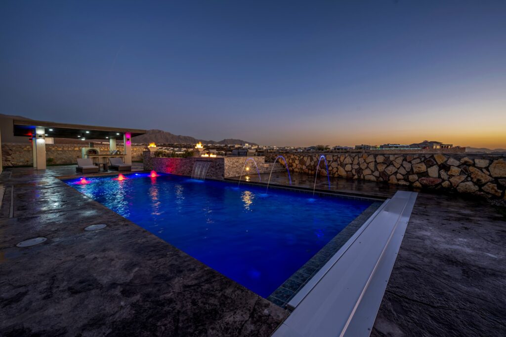 Custom swimming pool with LED lighting and water features in El Paso, TX