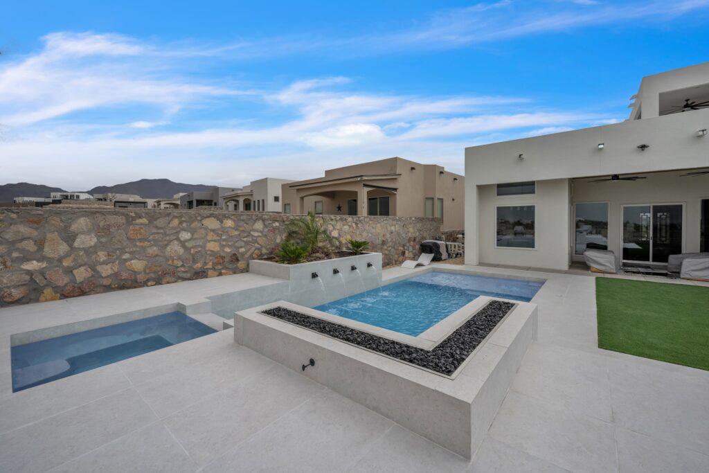 Close view of the raised spa and built-in fire feature beside the pool, part of a modern backyard designed by Eraland’s Custom Pools in El Paso, TX.